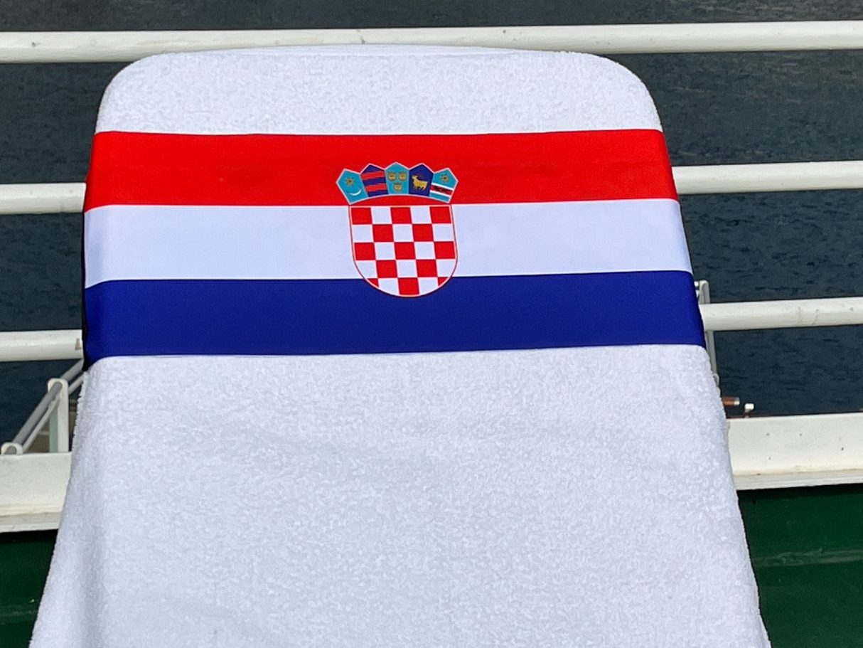 A Croatian National flag holding a towel onto a sun lounger. see tcboo.shop