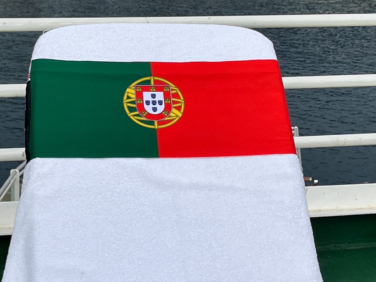 The National flag of Portugal holding a towel onto a sun lounger. see tcboo.shop